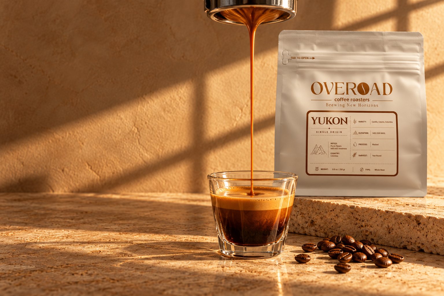 A double espresso pouring into a glass beside the YUKON bag on travertine